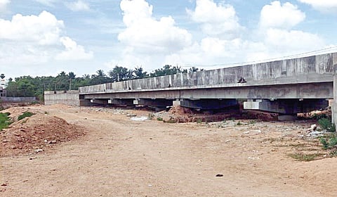 முருகன் குடியிருப்புக்கு செல்லும் சாலையில் வேகவதி ஆற்றின் குறுக்கே பாதியில் நிறுத்தப்பட்டுள்ள மேம்பால பணிகள்.
