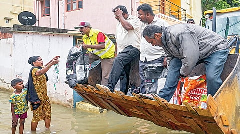 கனமழையால் வெள்ளத்தில் மூழ்கி உள்ள பெங்களூருவின் சாய் லேஅவுட் பகுதி மக்களுக்கு அத்தியாவசிய பொருட்களை மீட்புப் படை வீரர்கள் நேற்று விநியோகம் செய்தனர்.படம்: பிடிஐ