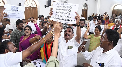 கோவை மாநகராட்சி கூட்டத்தில் அதிமுக கவுன்சிலர் பிரபாகரன் பதாகையை காட்டிய நிலையில், அதனைப் பறிக்க முற்படும் திமுக கூட்டணி கவுன்சிலர்கள். | படம்: ஜெ மனோகரன்