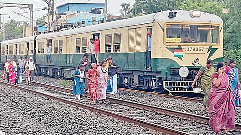 நுங்கம்பாக்கத்தில், மின்சார ரயில் சேவை பாதிக்கப்பட்டதையடுத்து, ரயிலில் இருந்து இறங்கி சென்ற பயணிகள்.