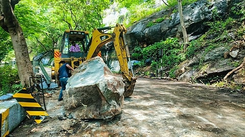ஏற்காட்டில் மலைப்பாதையில் சரிந்து விழுந்த பாறையை அகற்றும் பொக்லைன் இயந்திரம்.