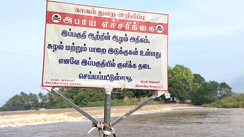 தேனி வீரபாண்டி முல்லை பெரியாற்றின் கரையில் வைக்கப்பட்டுள்ள அபாய எச்சரிக்கை அறிவிப்பு பலகை.