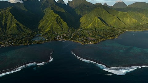 Surf breaks onto the lagoon in Teahupo'o, Tahiti, French Polynesia