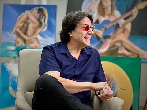 Fernando Dávila, a colourblind painter, speaks during an interview with The Associated Press at his gallery in Doral