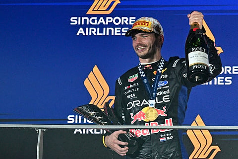 Max Verstappen celebrating his first Singapore Grand Prix win under the Marina Bay night lights in 2026.