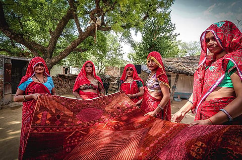 Artisans holding a rug