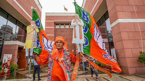 A BJP supporter during the celebration of the party's lead amid the counting of votes for the Lok Sabha elections, at the party office, in New Delhi, Tuesday, June 4, 2024