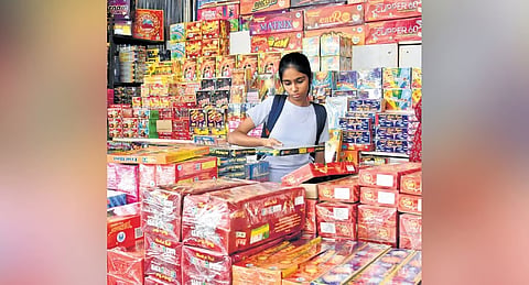 A girl selects firecrackers at a temporary stall set up in Basavangudi, on Monday
