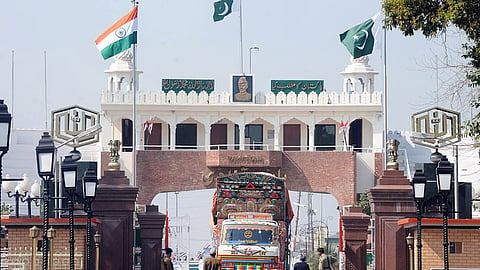 Indian Border Security Force (BSF) personnel (L) and Pakistani Rangers (R) allow a Pakistani truck to cross over to India at the Wagah Border