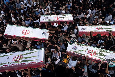 Mourners carry the flag-draped coffins of five men