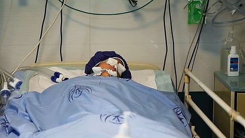 A Boy unconscious in a hospital bed