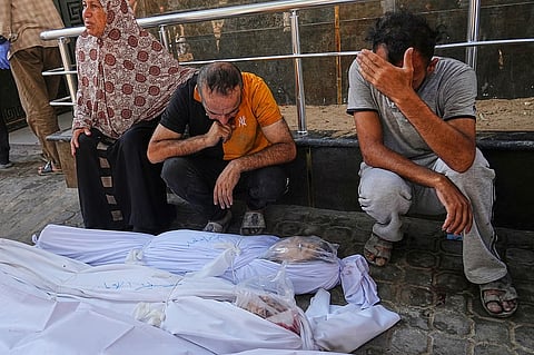 Relatives of two girls, Cila and Baraa al-Attar, who were killed along with others in an Israeli strike in the northern Gaza Strip, mourn over their bodies at Shifa
