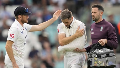 England's Chris Woakes walks off the field after his left shoulder got injured while fielding during the fifth Test cricket match between India-England.