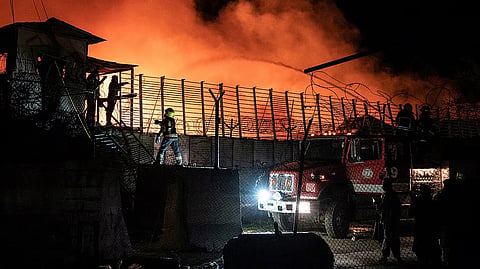 Afghan firefighters and Taliban security personnel.