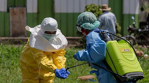 A Red Cross worker disinfects after transporting the bodies of people who died of Ebola from a health center in Rwampara, Congo, Wednesday, May 20, 2026.