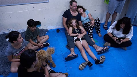 People take shelter as air raid sirens warn of incoming Iranian missiles in Ramat Gan, Israel, Monday, June 8, 2026.