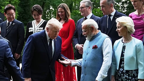 India's Prime Minister Narenda Modi helps U.S. President Donald Trump to get on a step before a group photo of leaders at the G7 summit.
