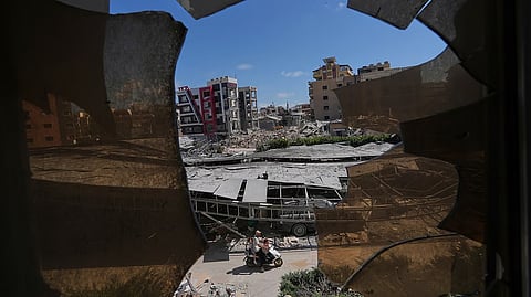Buildings damaged by Israeli strikes are seen through shattered glass from the Jabal Amel Hospital in the southern port city of Tyre, Lebanon,