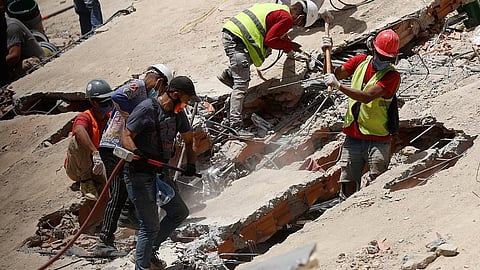 Rescue worker search through the rubble of a collapsed building