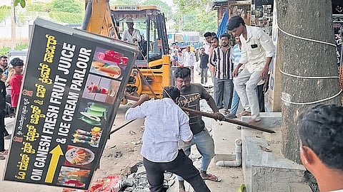 GBA workers remove signboards from a footpath to clear way for pedestrians in Thanisandra on Thursday