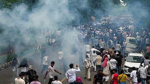 Security personnel fire tear gas shells.