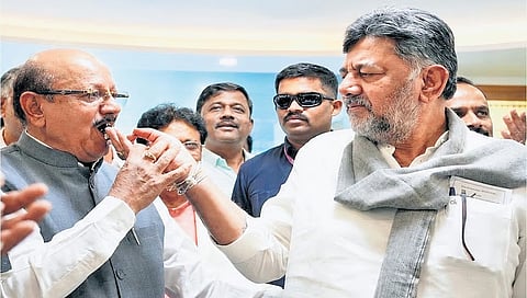 DK Shivakumar feeds a piece of cake to TB Jayachandra