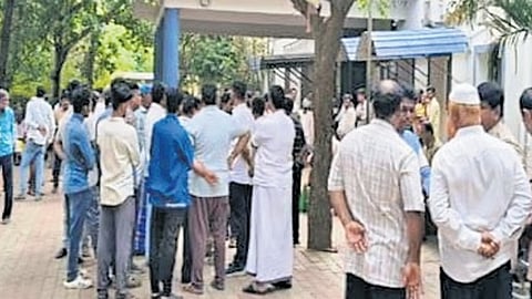 A large crowd gathers at the Hagaribommanahalli police station