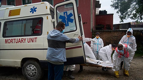 Nepal police officers prepare to load the bodies of flash flood victims for transport from a morgue for mass burial in Kathmandu, Nepal, Tuesday, Sept. 1, 2026