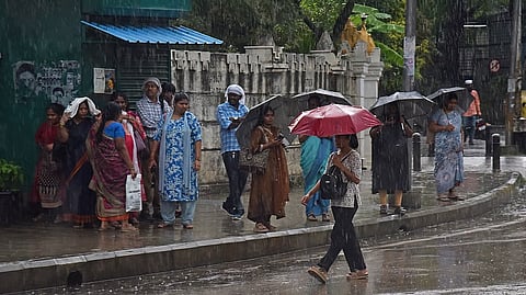 working women walk with Umbrella on rainy on Monday evening in Bengaluru on Monday.