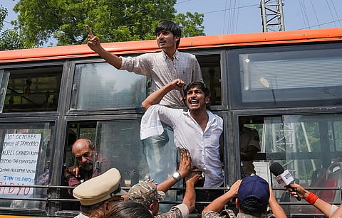 Demonstrators shout slogans from inside a police vehicle after being detained during a protest demonstration organised by the Cockroach Janta Party