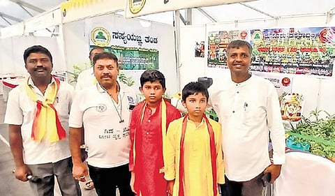 Santhosh Madenuru offers free saplings to people who sing Kannada song at Dasara Book Fair.