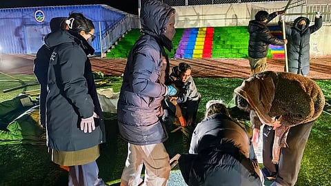 people set up tents for quake-affected residents at a primary school