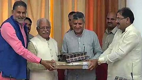 ಶಾಸಕರಿಗೆ ಲ್ಯಾಪ್ಟಾಪ್ ವಿತರಿಸುತ್ತಿರುವ ಖಟ್ಟರ್