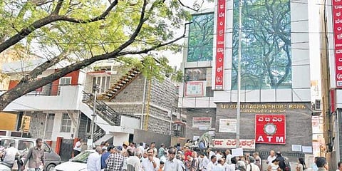 ಬ್ಯಾಂಕ್ ಬಳಿ ನಿಂತಿರುವ ಖಾತೆದಾರರು