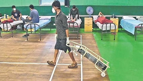 ಬೆಂಗಳೂರಿನ ಆಡುಗೋಡಿಯ ತಾತ್ಕಾಲಿಕ ಕೋವಿಡ್ ಕೇರ್ ಕೇಂದ್ರದಲ್ಲಿ ಆಕ್ಸಿಜನ್ ಸಿಲಿಂಡರ್ ಕೊಂಡೊಯ್ಯುತ್ತಿರುವ ವಾರ್ಡ್ ಬಾಯ್