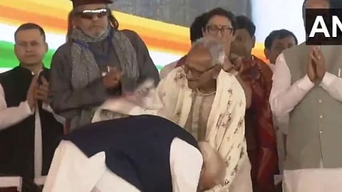 மேற்கு வங்க முதல்வர் பதவியேற்பு விழாவில் பா.ஜனதா-வின் 98 வயது தொண்டரின் காலில் விழுந்து ஆசி பெற்ற மோடி