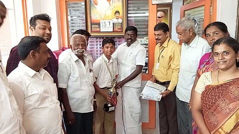 மாணவரின் சாதனையை பாராட்டி தெற்கு மாவட்ட தி.மு.க. செயலாளர் சிவபத்மநாதன் பரிசு வழங்கிய காட்சி.