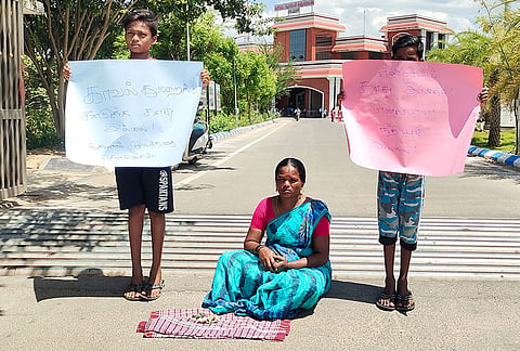 2 மகன்களுடன் தர்ணாவில் ஈடுபட்ட பெண்ணை படத்தில் காணலாம்.