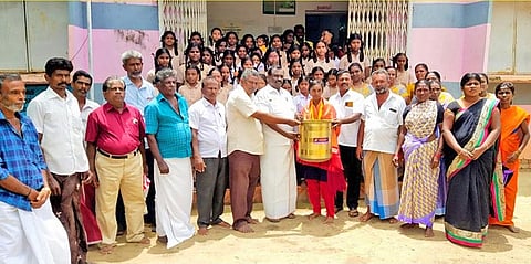 மாணவியை பாராட்டி பித்தளை பாத்திரம் வழங்கப்பட்ட காட்சி.