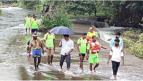 கொட்டும் மழையில் வாலிபரை தேடும் பணியில் ஈடுபட்டுள்ள தீயணைப்புத்துறையினர்.
