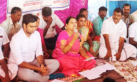 கிராம சபை கூட்டத்தில் அமைச்சர் கீதாஜீவன் பேசிய காட்சி. அருகில் மார்க்கண்டேயன் எம்.எல்.ஏ. உள்ளார்