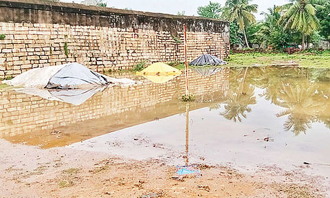 கொள்முதல் நிலையத்தில் நெல்லை சூழ்ந்துள்ள மழைநீர்.