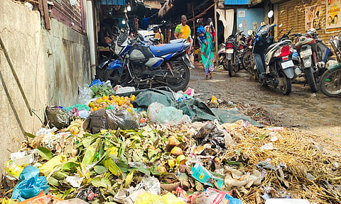 பூ மார்க்கெட்டில் குவிந்து கிடக்கும் குப்பைகளை படத்தில் காணலாம். 