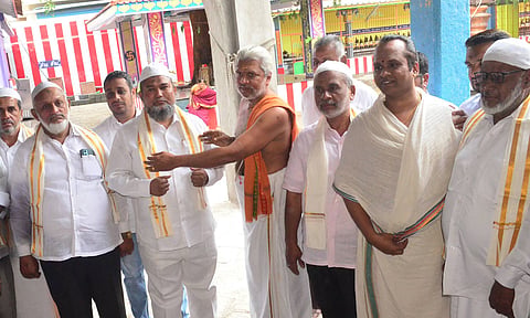 கோவை கோட்டை மேடு ஈஸ்வரன் கோவிலுக்கு சென்ற ஜமாத் அமைப்பு நிர்வாகிகளை கோவில் பூசாரி சால்வை அணிவித்து வரவேற்ற காட்சி.