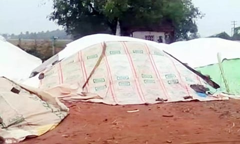 கொள்முதலுக்காக வைக்கப்பட்டிருந்த நெல்மணிகள் நனையாமல் இருக்க தார்ப்பாய் கொண்டு மூடப்பட்டுள்ளது.