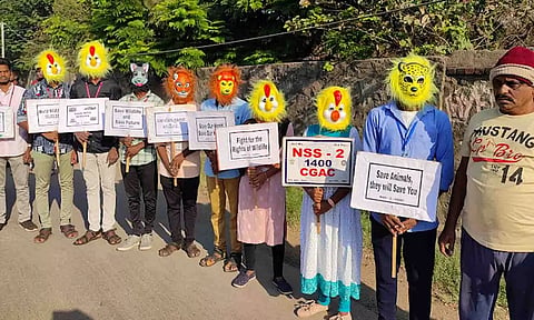வனவிலங்குகள் பாதுகாப்பை வலியுறுத்தி முகமூடி அணிந்து, மனித சங்கிலி அமைத்தும் விழிப்புணர்வு ஏற்படுத்திய காட்சி.