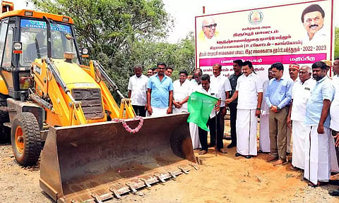 சாலை தரம் உயர்த்தும் பணியை அமைச்சர் மு.பெ.சாமிநாதன் தொடங்கி வைத்த காட்சி. அருகில் கலெக்டர் வினீத் மற்றும் பலர் உள்ளனர். 