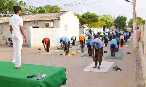 போலீசாருக்கு யோகா பயிற்சி மேற் கொண்ட காட்சி.