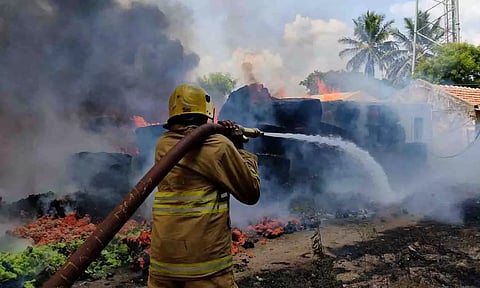  தண்ணீரை பீய்ச்சியடித்து தீயை அணைக்கும் தீயணைப்பு வீரர்கள்.