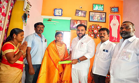 செஞ்சி பேரூராட்சி மன்ற தலைவர் மொக்தியார் மஸ்தான் மாணவி ஒருவருக்கு சால்வை அணிவித்து இனிப்பு வழங்கிய காட்சி. 